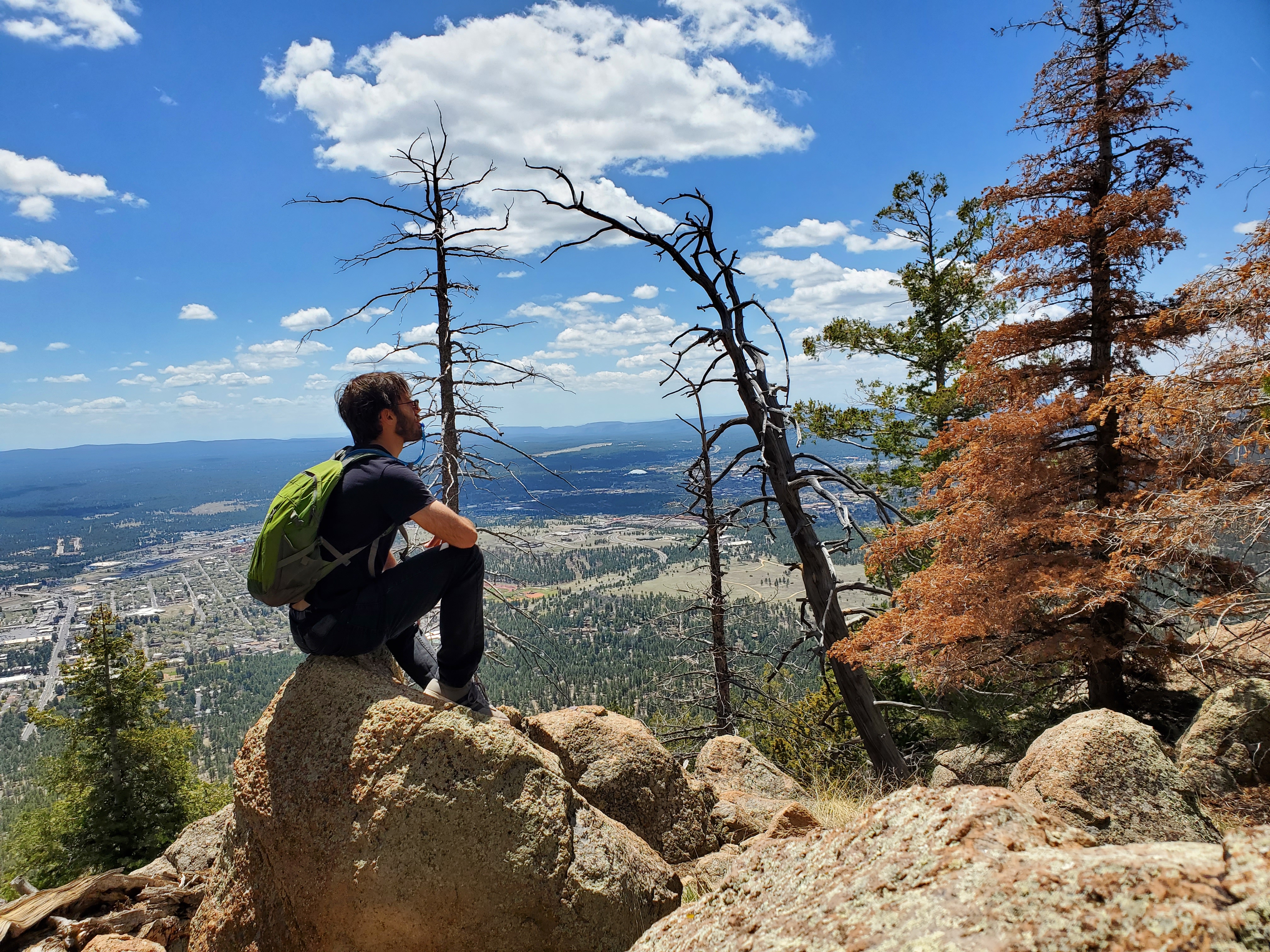 Adam Petrucci taking pause on a boulder while hiking Mount Elden in Arizona.