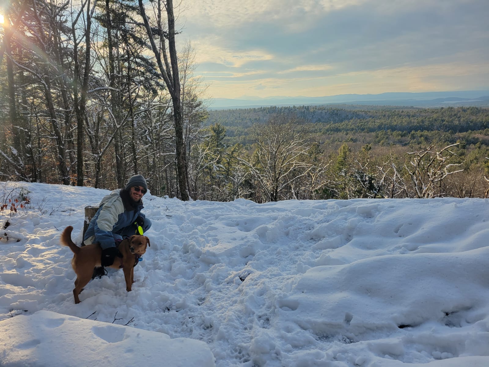 Adam Petrucci hiking in the snow in Vermont with a pet dog.
